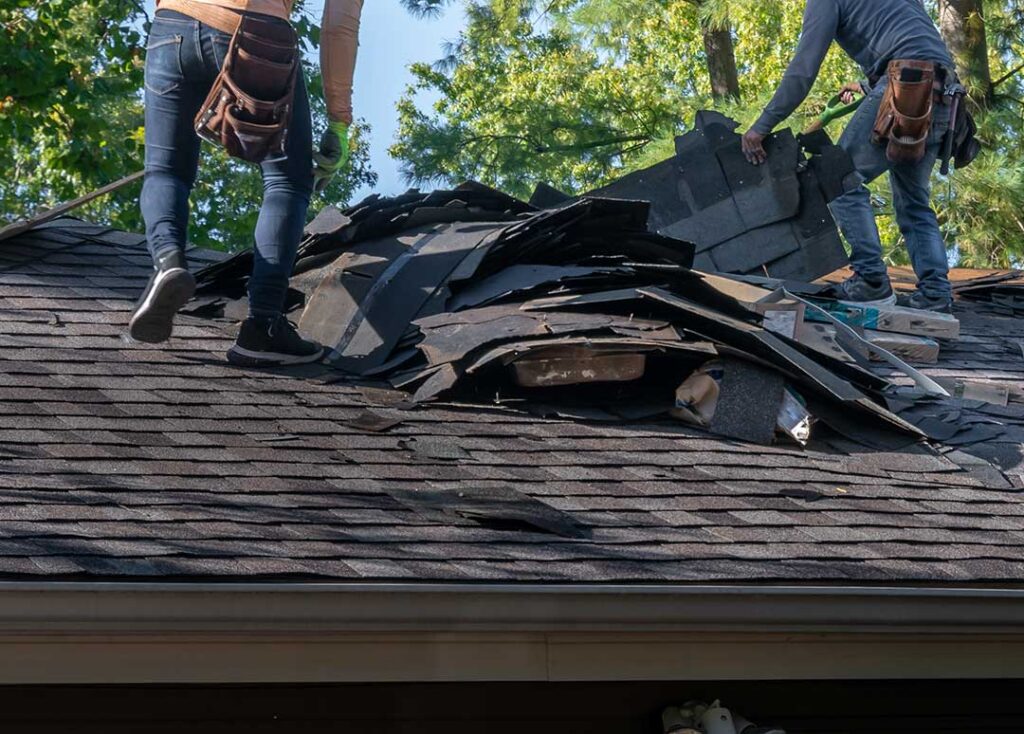 Homeowner checks roof gutters and tiles from the ground after a rainy, windy day.